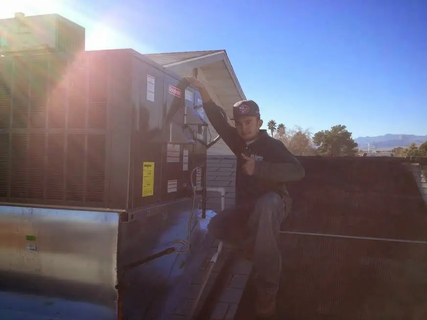 HVAC technician performing Air Duct Cleaning on a rooftop unit in Reidsville